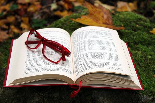 Buch geöffnet mit einer Lesebrille