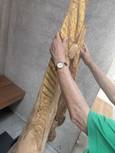 Eine Engel oder Marien ähnliche Figur aus Holz wird mit zwei Händen abgetastet.
